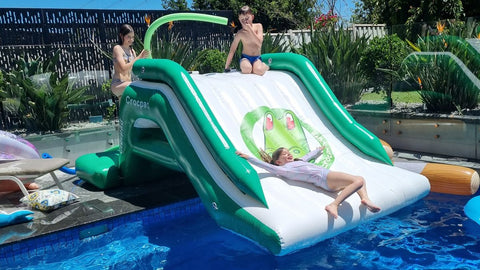 Inflatable water slide in a pool with children playing